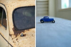 Närbild på en rostig gammal veteranbil bredvid en blå leksaksbil.